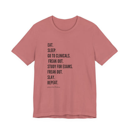 Nursing Student Tee — “Eat. Sleep. Go to Clinicals. Freak Out. Study for Exams. Freak Out. Slay. Repeat.”