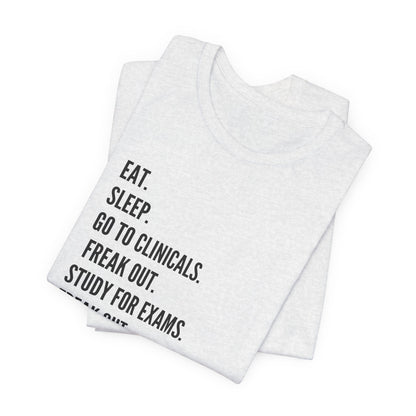 Nursing Student Tee — “Eat. Sleep. Go to Clinicals. Freak Out. Study for Exams. Freak Out. Slay. Repeat.”