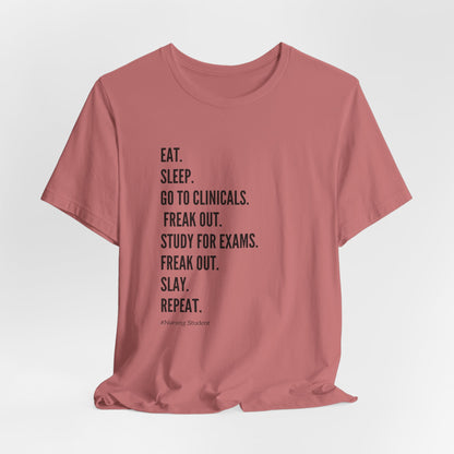 Nursing Student Tee — “Eat. Sleep. Go to Clinicals. Freak Out. Study for Exams. Freak Out. Slay. Repeat.”